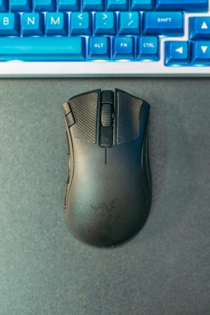 Close-up image of a modern black wireless gaming mouse on a desk.